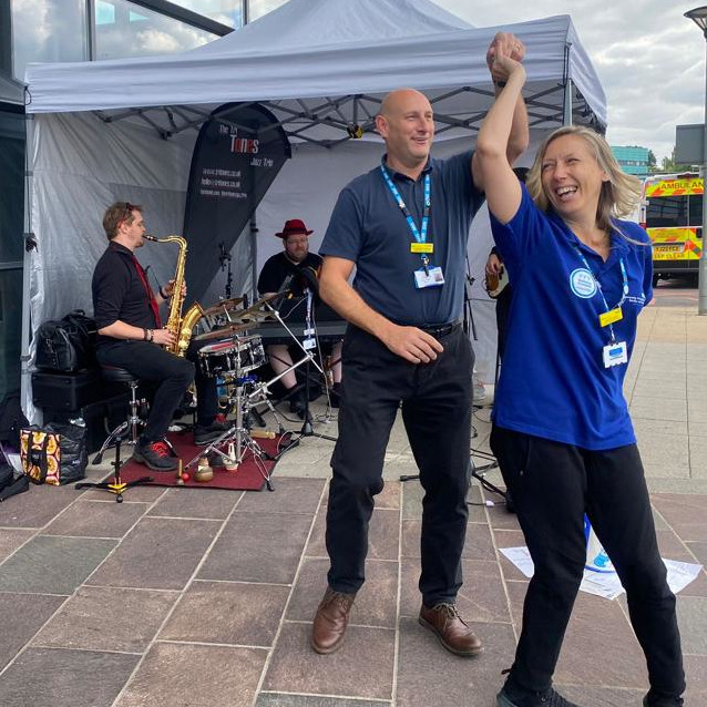 Tri Tones trio performing at UHDB Royal Derby Hospital Buskathon with two members of wellbeing staff dancing alongside